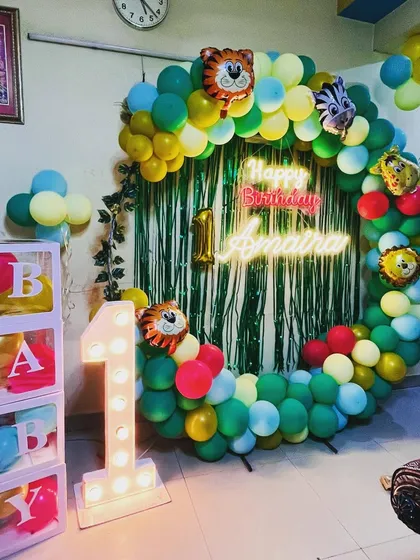 A closer look at the jungle-themed first birthday decor. The details like the ivy vines on the balloon ring and the animal foil balloons make the theme more realistic.