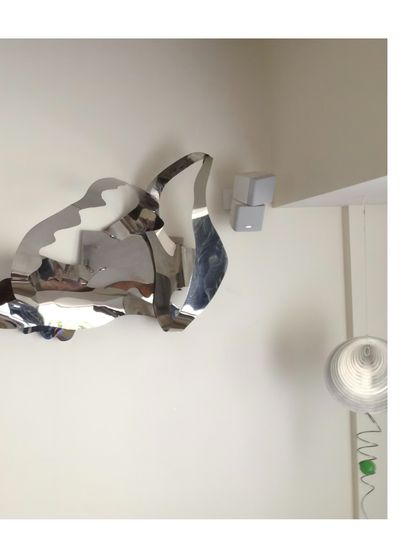 A detail of the 2017 installation, showing how the polished steel reflects and distorts its surroundings.