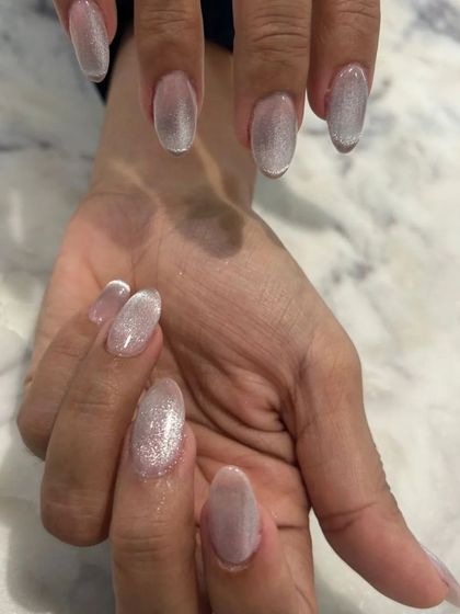 This angle shows how the light plays across the silver-white cat-eye nails, creating a beautiful, glowing effect.