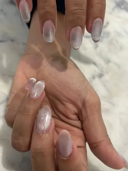 This angle shows how the light plays across the silver-white cat-eye nails, creating a beautiful, glowing effect.