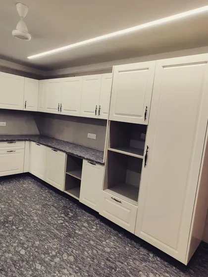 This view highlights the tall pantry and appliance unit, which integrates the refrigerator and provides floor-to-ceiling storage, maximizing the utility of the space.