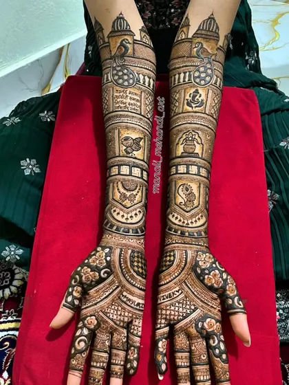 A beautiful example of a traditional full-arm bridal mehandi. The design is packed with classic motifs like Ganesha for blessings, a kalash, peacocks, and intricate jaal (net) patterns for a timeless look.