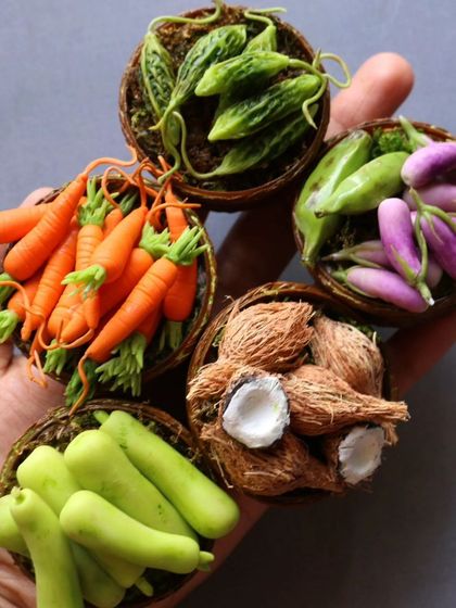 A handful of my miniature vegetable baskets, including carrots, brinjal, and coconuts.