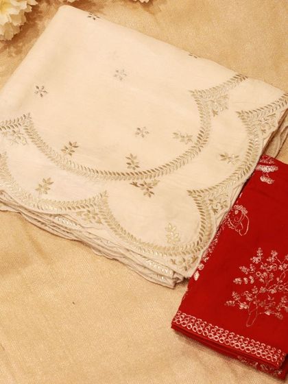 The complete set of the cream Tussar silk saree and its contrasting red embroidered blouse piece.