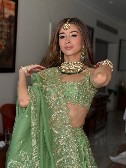 A closer look at the makeup and jewelry details, including the maang tikka and layered necklace.