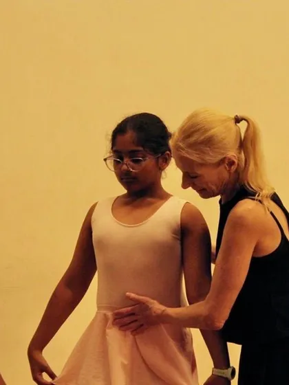 The foundation of ballet is built with careful guidance. Here, our Artistic Director Yana Lewis works with a young dancer, focusing on the precise posture and form that ensures safety and fosters growth from the very first step.