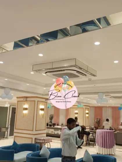 A wide shot of a banquet hall with simple balloon bunches on the ceiling, showing how to fill a large space.
