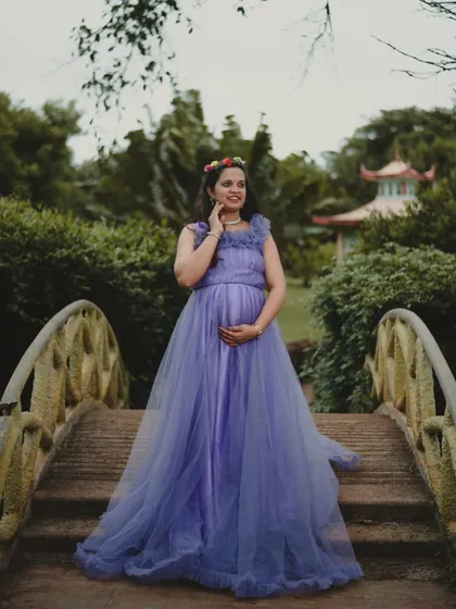 A solo portrait on a bridge in a Japanese-style garden. The lavender-blue gown and floral crown create a harmonious and picturesque scene.