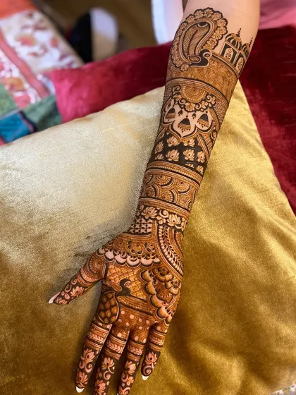 A single arm view of a bridal design, showcasing the intricate details. You can see a large paisley motif, architectural elements, and delicate bands creating a layered look.