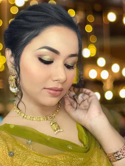 A beautiful festive look with a soft green and gold eyeshadow. The lashes are styled to be longer at the outer corners, creating a subtle cat-eye effect that elongates the eyes.