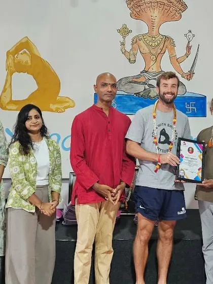 A student from the Thailand batch is congratulated on completing the intensive 10-day yoga workshop.