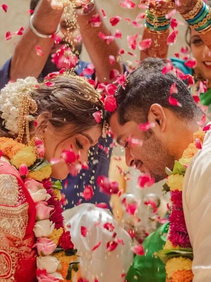 A beautiful candid moment from a wedding ceremony. The bride's intricate hairstyle is visible as she shares a special moment with her groom.
