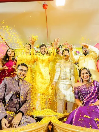 The entire family joins in on the fun. This group shot shows the collective joy and celebration of the haldi ceremony.
