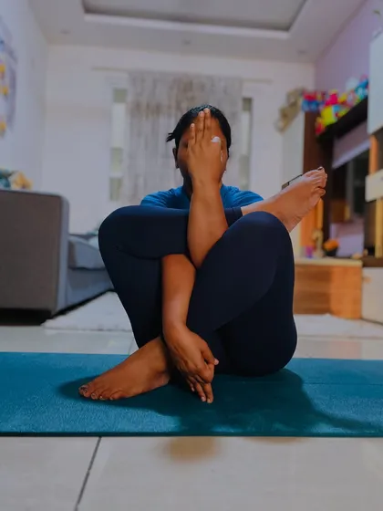 A student in a complex seated twisting pose. These asanas are excellent for detoxification and improving spinal mobility, but they require patience to master.