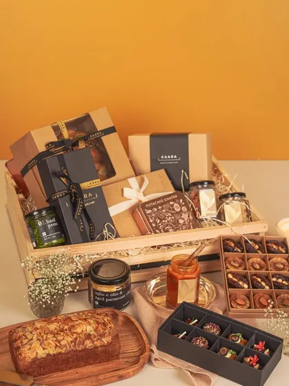 Our grand festive hamper, presented in a reusable wooden crate, is designed for generous gifting. It’s brimming with a curated selection of our finest products, including an almond tea cake, modern Indian sweets, basil pesto, and other gourmet jars, making it a truly impressive and memorable gift.