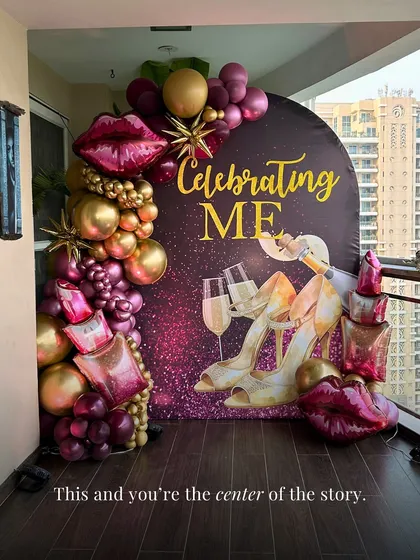 This one is all about "Celebrating ME." We created this glamorous backdrop for a self-love themed party, featuring a custom arch, a cascade of gold and burgundy balloons, and fun, chic details like lipstick and champagne foil balloons.