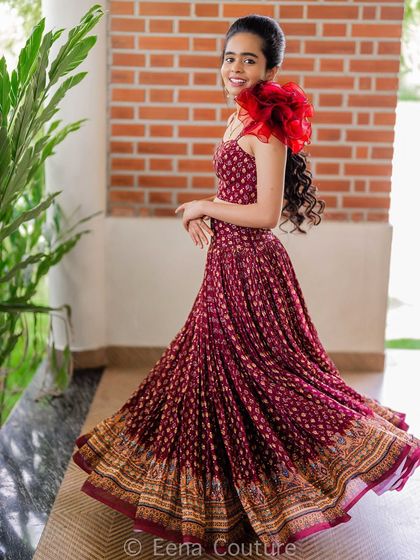 For Nisarga, I also created this beautiful maroon printed co-ord set. The pleated skirt gives it a wonderful twirl, and I added a dramatic ruffled organza flower on one shoulder for a touch of modern flair.