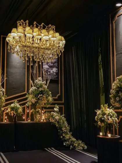 Another view of the memory lane, showing how the combination of personal photos, elegant florals, and dramatic lighting created a powerful and emotional focal point at the event's entrance.