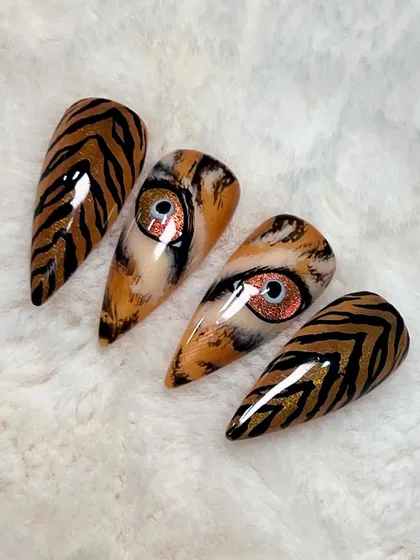 Bring me your boldest ideas. I hand-painted this realistic tiger's eye and stripes, using fine brushes and layering colors to create depth and a striking, lifelike effect on stiletto nail tips.