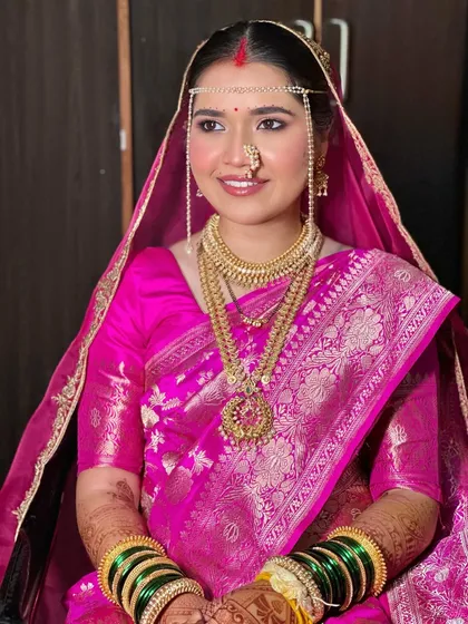 The complete traditional look with the 'mundavalya' (forehead ornament). Her makeup is subtle yet defining, honoring every aspect of the Maharashtrian bridal tradition.
