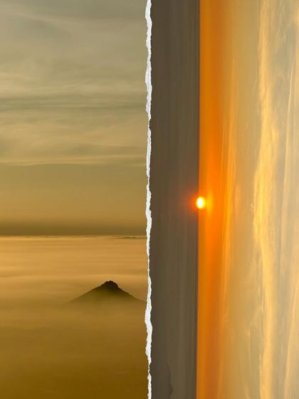 The golden hour at Kaiwara Betta, with the sun rising over a blanket of clouds.