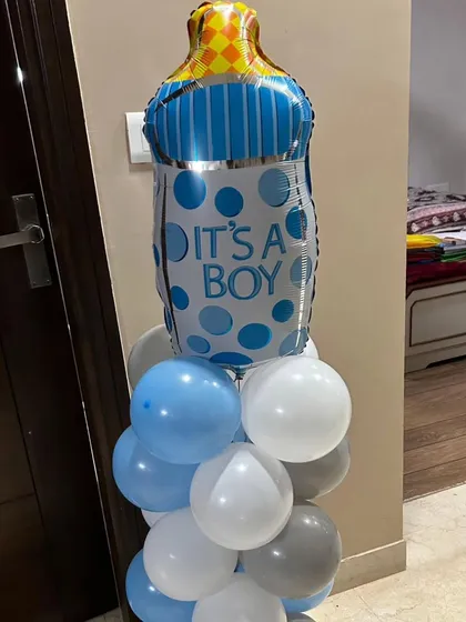 A small balloon stand with an "It's a Boy" baby bottle foil balloon. This is a great add-on element for any welcome home decoration package.