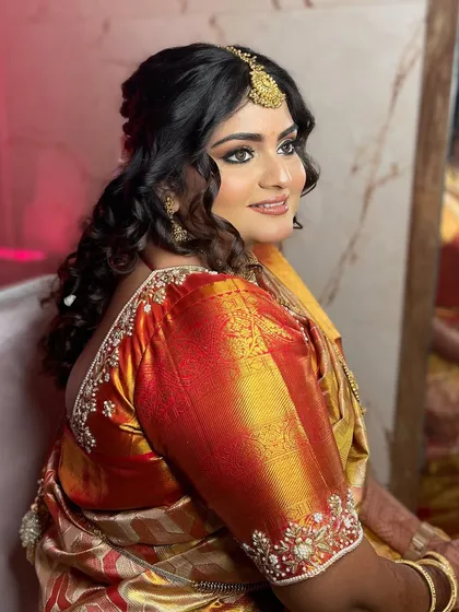 My bride Divya, glowing for her Maharashtrian engagement. We created two traditional looks for her, one in a stunning royal blue saree and another in a beautiful orange one, both featuring classic bold eyes and radiant skin.
