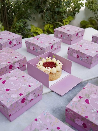 Our signature floral pink box, revealing a delicate mini cake inside. We believe in gifting joy, beautifully packaged for your happy moments.