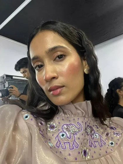 A selfie-style shot of the dewy, flushed look. You can really see the highlight and how the glossy lips complete this fresh and modern makeup style.