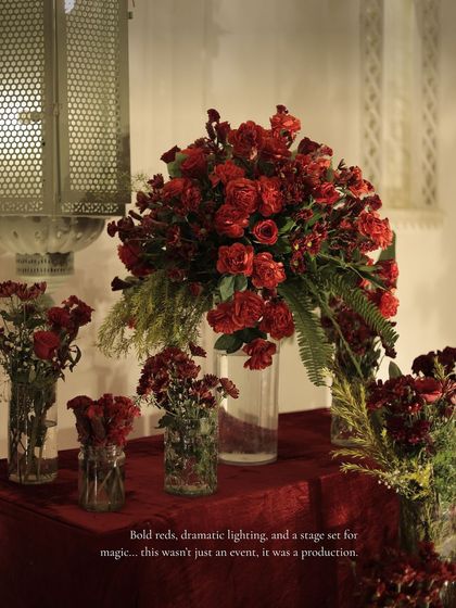 A dramatic floral arrangement of bold red roses, a key element in the Sangeet's romantic and theatrical decor scheme.