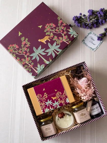 This hamper, in a rich purple jungle-themed box, is curated with love. It includes small jars of our gourmet snacks, a candle, and other delightful surprises.
