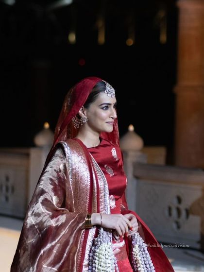 Kriti Sanon captured in a moment of grace, with the historic architecture of the ghats visible behind her, blending Bollywood glamour with ancient heritage.