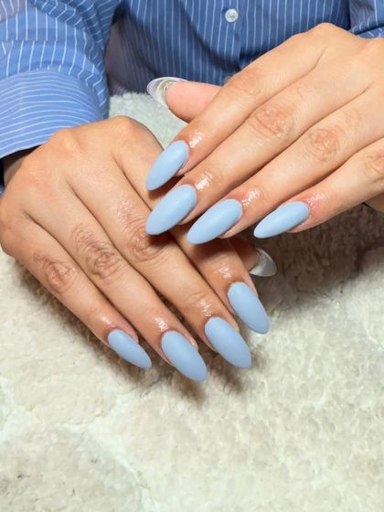 A simple and chic set of long, almond-shaped extensions in a solid, matte light blue.