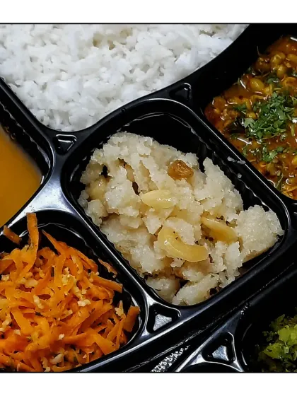 A simple and light meal featuring khatti meethi dal, rice, tinda sabzi, moong gravy, carrot salad, and a pure ghee dry fruit sheera.