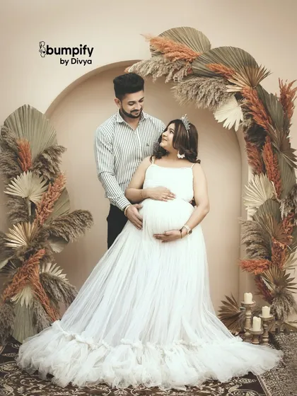 The couple shares a loving gaze in this romantic shot. The earthy tones of the backdrop create a warm and intimate atmosphere for their pregnancy portraits.