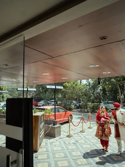 A Sikh couple arriving at their wedding venue, captured from the entrance.