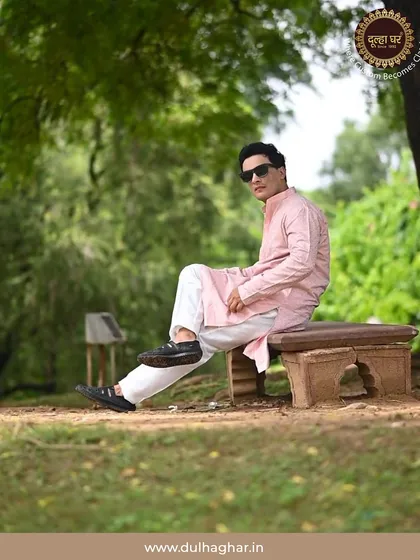 A model relaxes in a park wearing a pink kurta and white trousers. This image shows the comfort and versatility of my classic kurta sets for outdoor settings.