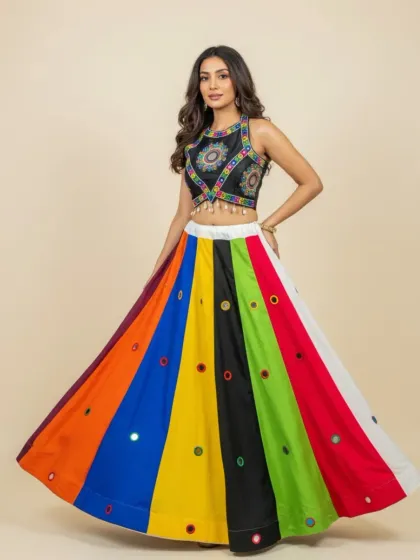 For vibrant celebrations like Navratri or a Mehendi ceremony, I offer colorful and fun outfits. This multi-colored lehenga with mirror work and a detailed black blouse is designed to make you shine while you dance.