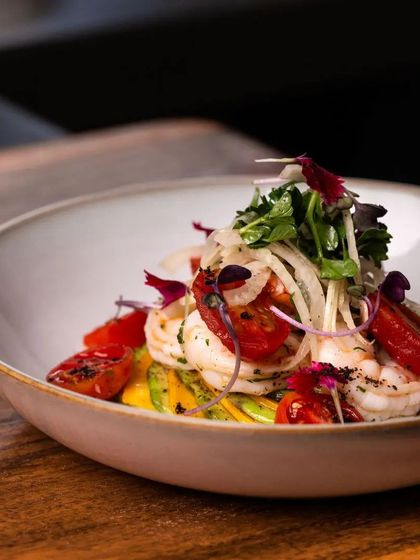 Indulge in the vibrant flavors of my avocado and mango carpaccio, served with succulent prawns and roasted plum tomatoes. It's a perfect combination of freshness and richness.