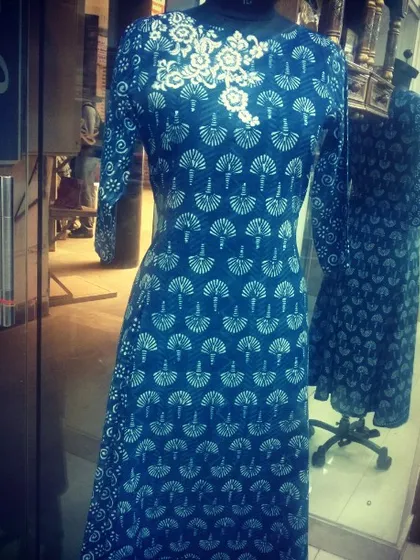 This long indigo kurta features a traditional block-print style pattern. To elevate the design, I added a contrasting white floral embroidery motif around the neckline, making it a unique piece for semi-formal wear.