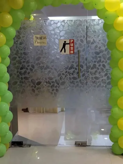 The entrance to an animal-themed party, marked by a simple yet inviting green and yellow balloon arch.