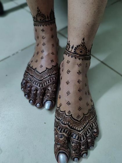 A minimal yet stunning design for bridal legs. The pattern covers the toes and ankle, leaving the middle of the foot open with delicate scattered butis for a modern and chic look.