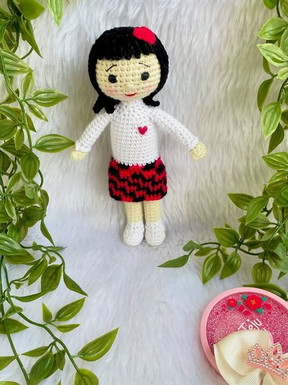 A replica doll of a sweet little girl in a skirt with a red and black pattern. I really enjoyed the challenge of the colorwork on the skirt to make it look just right.