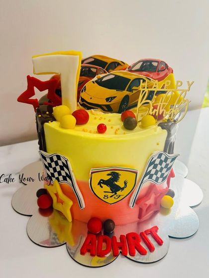 A vibrant Ferrari-themed cake in bright yellow and red, for a celebration with speed and style.