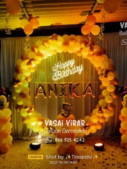 This outdoor Minnie Mouse setup for a fifth birthday uses a warm color palette of orange and yellow. The large balloon ring and character pillars create a fantastic focal point for an evening celebration.