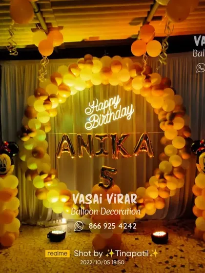 This outdoor Minnie Mouse setup for a fifth birthday uses a warm color palette of orange and yellow. The large balloon ring and character pillars create a fantastic focal point for an evening celebration.