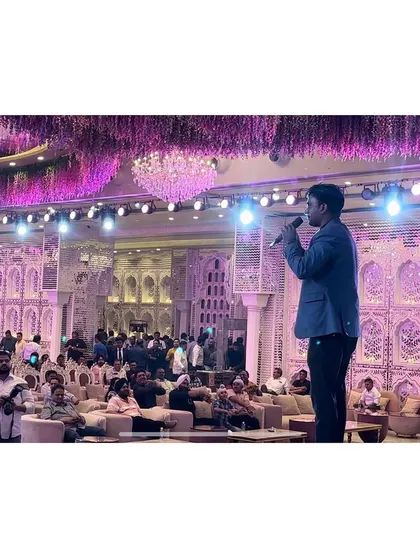 Addressing a large audience at a grand corporate event for Castrol. The scale of the venue and crowd shows my capability to handle major events.