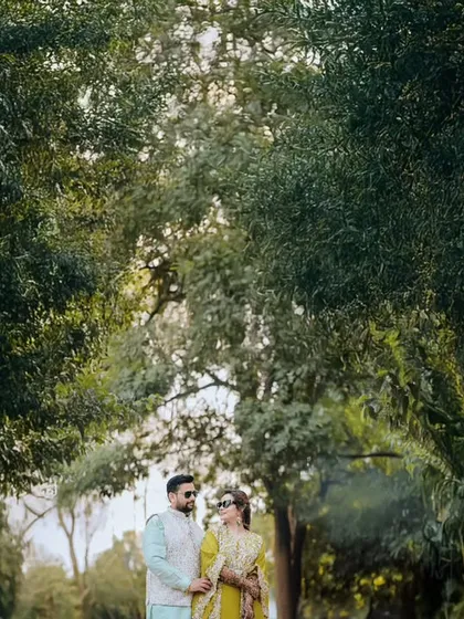 A serene portrait of the couple standing together amidst lush greenery. We use natural landscapes to create a beautiful and tranquil setting for your photos.