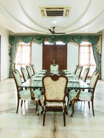 The royal dining room, featuring a 12-seater table, ornate gilded furniture, and a vaulted ceiling design, perfect for grand family gatherings.
