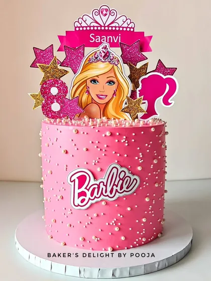 A glamorous and perfectly pink Barbie cake for an eighth birthday. This design is all about sparkle, with a glittery Barbie silhouette, star accents, and a pearl-studded finish.